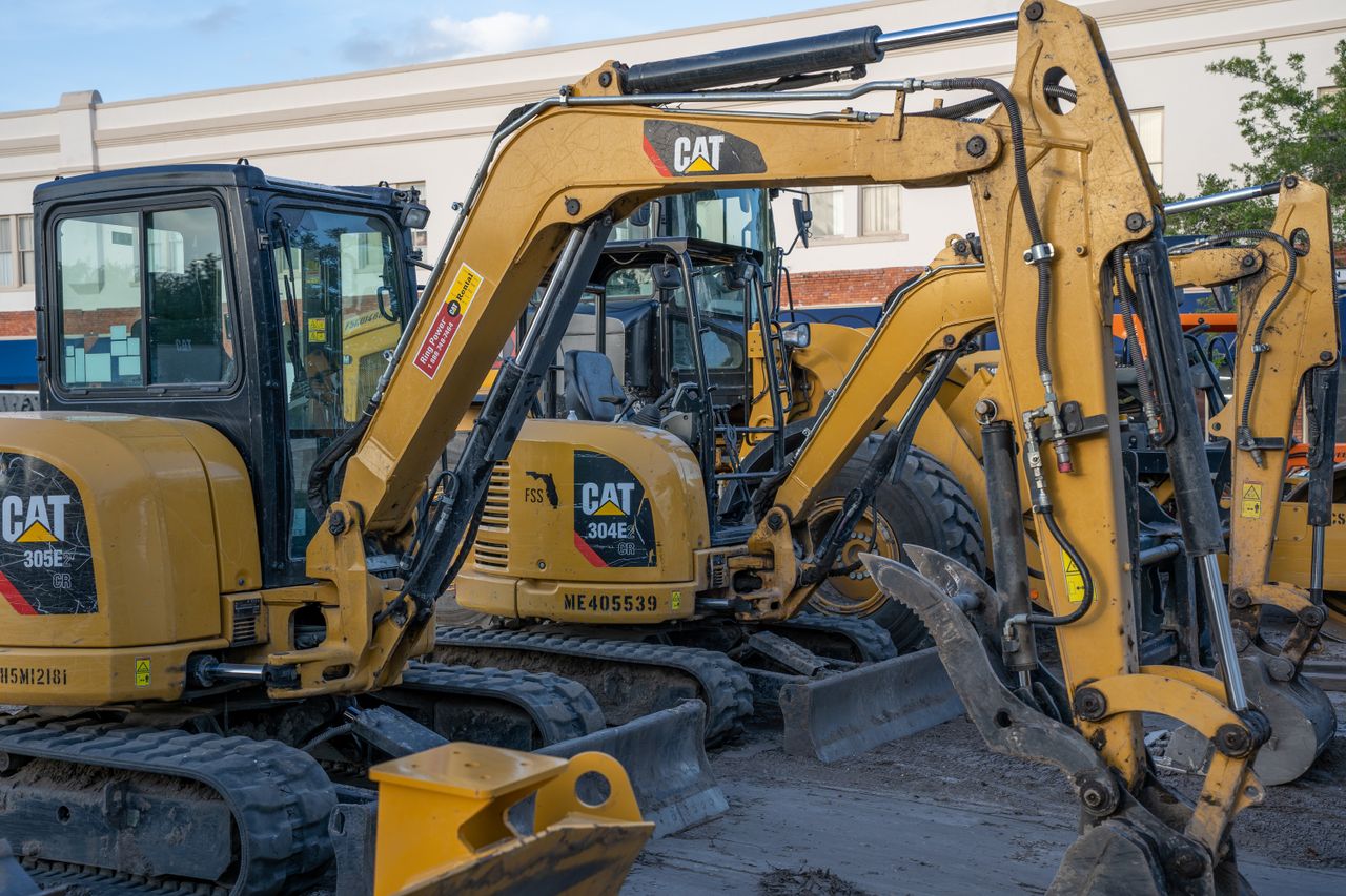 services-02 A row of parked excavators at a construction site, ready for heavy duty work.