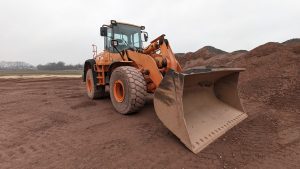 Heavy machinery excavator parked on a rural construction site in Werlte, Deutschland.