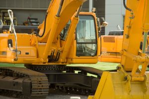 Close-up of yellow excavators at a construction site, showcasing industrial machinery and engineering.