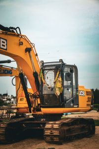 Yellow excavator at an outdoor construction site on a clear day.