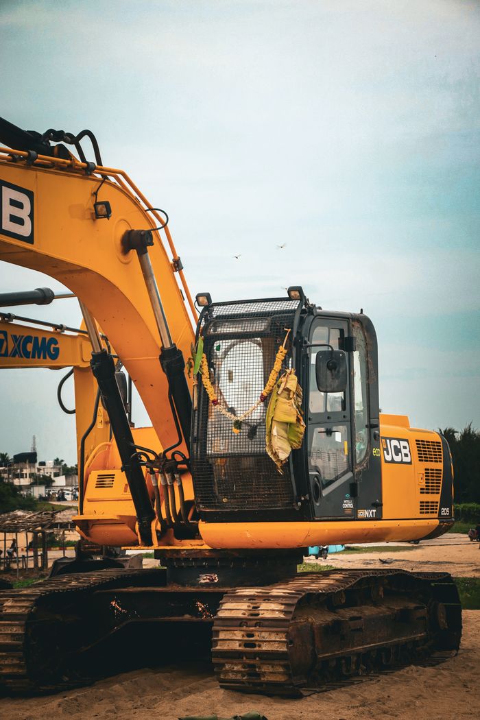 our-experience Yellow excavator at an outdoor construction site on a clear day.