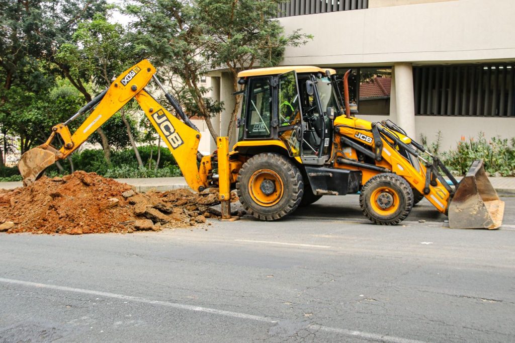 pexels photo 37333415 Street view of an excavator in Sandton, highlighting urban development and construction activities.